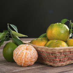 Fresh green tangerine mandarin orange on dark wooden table background.