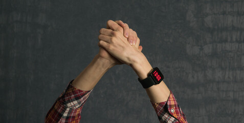 Hands of a man in a shirt with a watch on it
