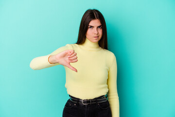 Fototapeta premium Young caucasian woman isolated on blue background showing thumb down, disappointment concept.