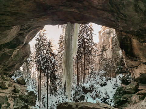 Winterliche Landschaft im Nationalpark S&auml;chsische Schweiz. Blick aus einer Grotte (Gautschgrotte) heraus auf einen gro&szlig;en Eiszapfen der von Felsdecke herabh&auml;ngt.