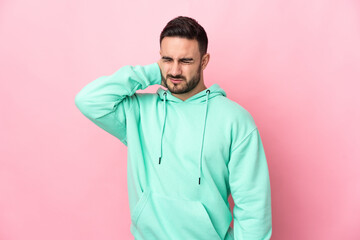 Young caucasian handsome man isolated on pink background with neckache