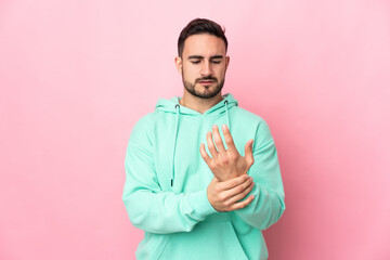 Fototapeta premium Young caucasian handsome man isolated on pink background suffering from pain in hands
