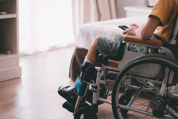Asian special child on wheelchair is have intention with using smart phone alone in bedroom...