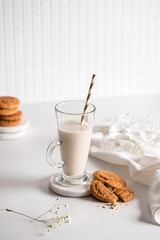 Glass of milk with homemade cookies on a white background. Breakfast and healthy food concept. white on white