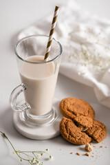 Glass of milk with homemade cookies on a white background. Breakfast and healthy food concept. white on white