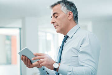 Confident executive using a touch screen tablet