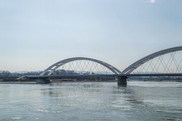 Fototapeta na wymiar Novi Sad, Serbia - March 08. 2021: Zezelj bridge on river Danube in Novi Sad Serbia. The prospect of built New Zezelj Bridge viewed from the Petrovaradin side of the promenade.