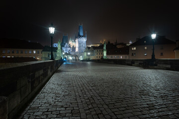 Fototapeta premium empty sidewalk on the illuminated Charles Bridge at night in the center of Prague