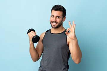 Young sport man with beard making weightlifting showing ok sign with fingers