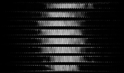 An abstract image of a coil of an automobile radiator of a cooling system, in backlight. The...