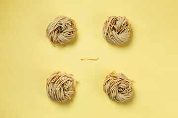 Fettuccine on yellow background. minimal composition about quality italian raw pasta. 