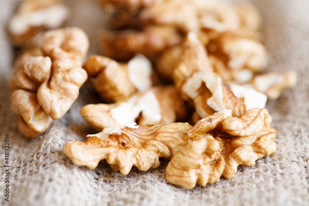 Poster peeled walnuts lie in a heap on sacking