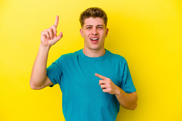Fototapeta premium Young caucasian man isolated on yellow background dancing and having fun.
