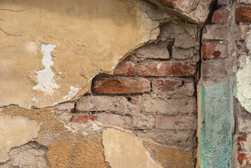 Naklejka premium Old damaged plastered facade house wall closeup as grunge background
