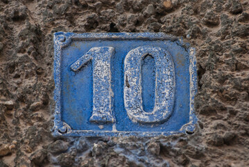 Old retro weathered cast iron plate with number 10 closeup
