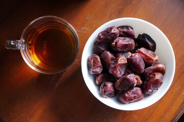 Dates and tea on the wooden table for breakfast