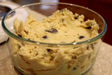 Homemade raw chocolate chip cookie dough stored in a glass bowl.