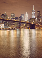 Fototapeta na wymiar Brooklyn Bridge and New York City skyline at night, color toning applied, USA.