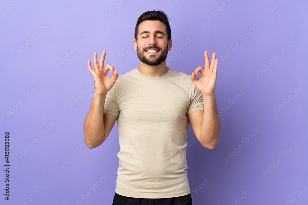 Sticker Young handsome man with beard over isolated background in zen pose