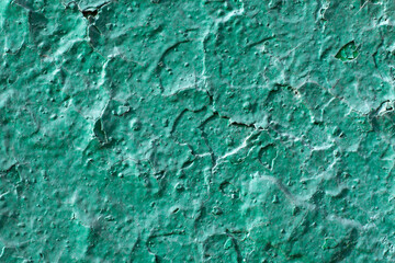 Green concrete wall with fractures and peeling coating. Textured abstract background
