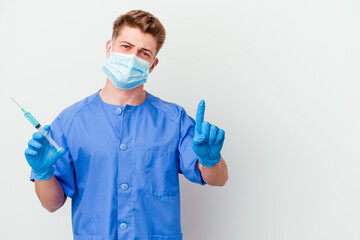 Young caucasian nurse man prepared to give a vaccine isolated on white background showing number one with finger.