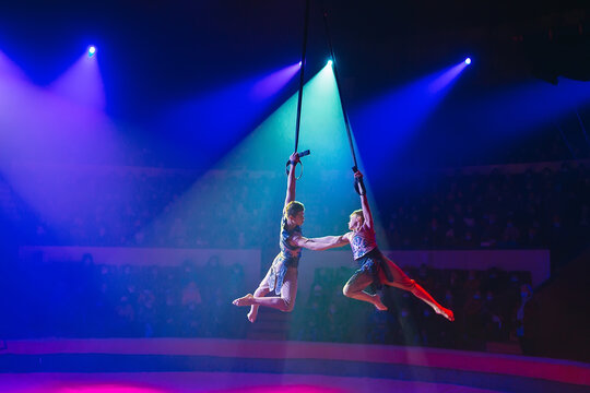 Circus Actress Acrobat Performance. Two Boys Perform Acrobatic Elements In The Air.