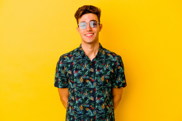 Fototapeta premium Young caucasian man wearing a Hawaiian shirt isolated on yellow background happy, smiling and cheerful.