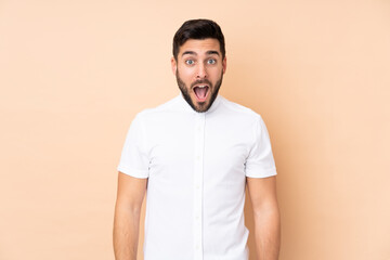Caucasian handsome man isolated on beige background with surprise facial expression