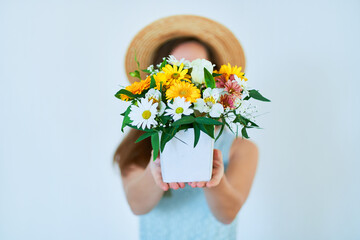 Woman holds decorative colorful bright fresh flower hat box at spring time