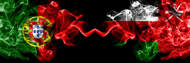 Portugal, Portuguese vs Oman smoky mystic flags placed side by side. Thick colored silky abstract smoke flags.