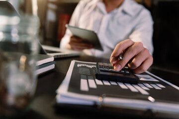 Hand man doing finances and  on desk about cost at office.