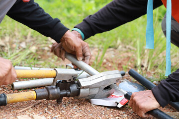 Hand of electrician repairman worker  cutting cable. Industrial mounting concept. Professional...