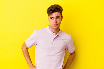 Young caucasian man isolated on yellow background confused, feels doubtful and unsure.