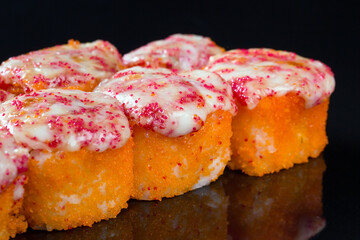 Sushi rolls with squid, mussel and cheese on a black background.