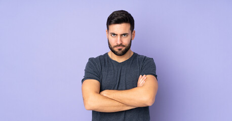 Caucasian handsome man with unhappy expression over isolated purple background