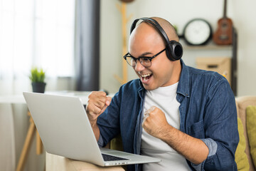 Young handsome asian man meeting and conferencing online keep social distancing talking with his business team online or study online course. He wearing headset.