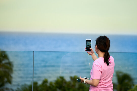 woman traveler take pictures of beach view