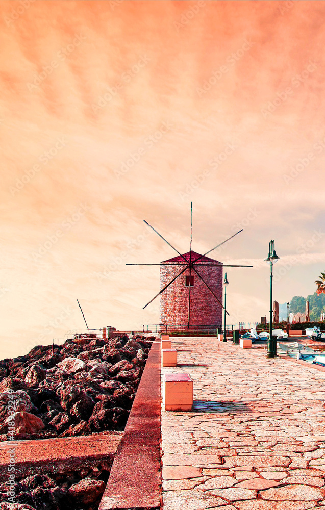 Wall mural charming seafront view with stones, lanterns and old windmill on the coast of the mon repose area in