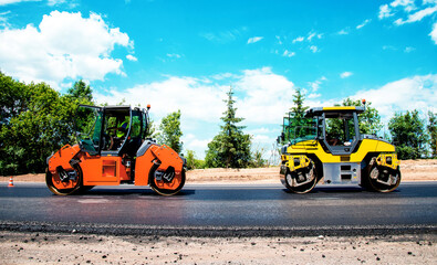 industrial landscape with rollers that rolls a new asphalt in the roadway. Repair, complicated...