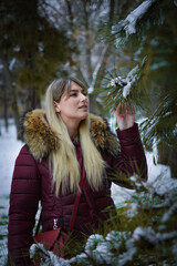 Beautiful blonde girl walking in the park on snowy winters day.