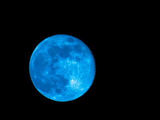 Obraz premium Earth's Moon Glowing with different colours in the Background. Blue and red moon watched by telescope.
