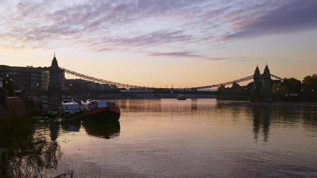 Sunrise on the River Thames in Hammersmith, London, with Hammersmith Bridge in the background. Zoom out