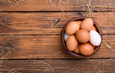 Fresh eggs from organic farms Put in a wooden bowl placed on a wooden table in the kitchen - top view.