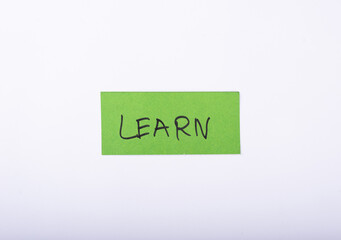 Learn word written on a Green color sticky note with a White background.