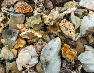 A mcaro photograph of a heap of various rocks and minerals full of interesting shapes, sizes and textures with a slight defocused effect. A delight for the rock collector