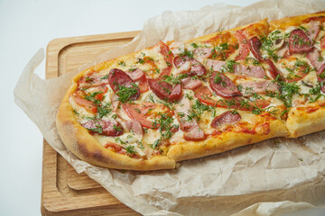 Freshly baked pizza margherita with smoked sausages, bacon, red sauce and mozzarella on a wooden tray on a gray background. Italian Cuisine