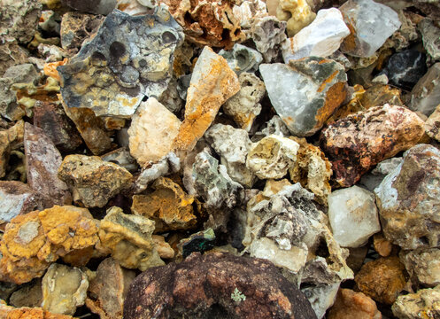 A macro photograph of different shapes and sizes of rocks and minerals makes an interesting background or texture. Slight bokeh effect.