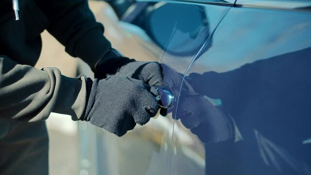 Thief Breaks Lock On Vehicle. Car Jacking Thief Steal Car Breaking Door. Criminal Bandit Job Burglar Hijacks Auto.Street Crime Violence Gangster Robber. Vandalism Crime Theft Using Tool For Open Door.