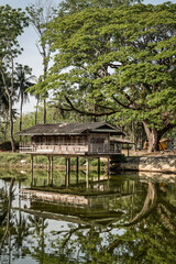 Fototapeta na wymiar Old pavilion in the water With big trees