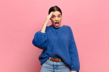 young pretty woman looking happy, astonished and surprised, smiling and realizing amazing and...
